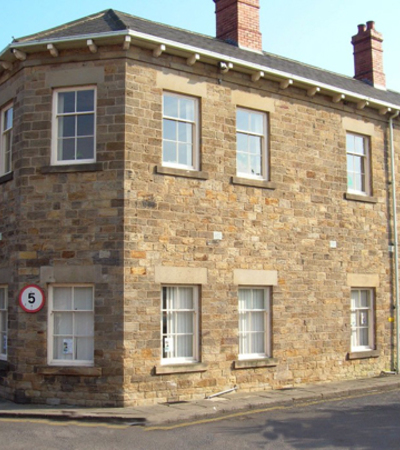 A stone building on a junction between two roads