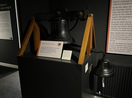 Replica works bell - large black iron bell on a stand and smaller black bell to the side