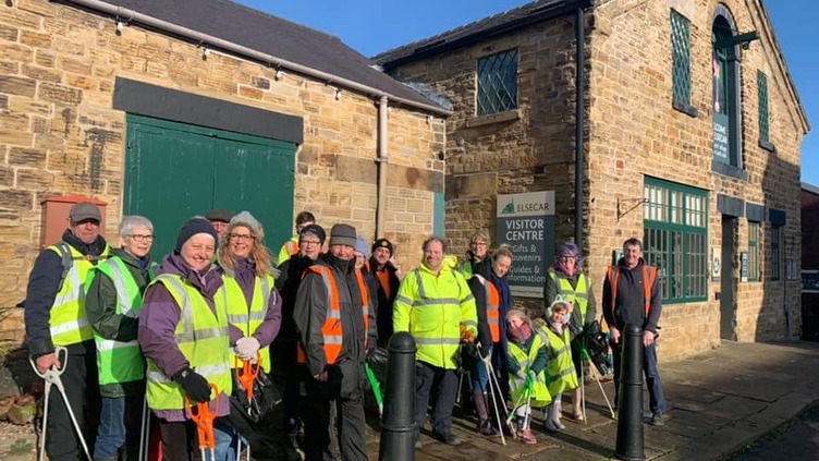 Litter picking volunteers in high vis vests outside the visitor centre