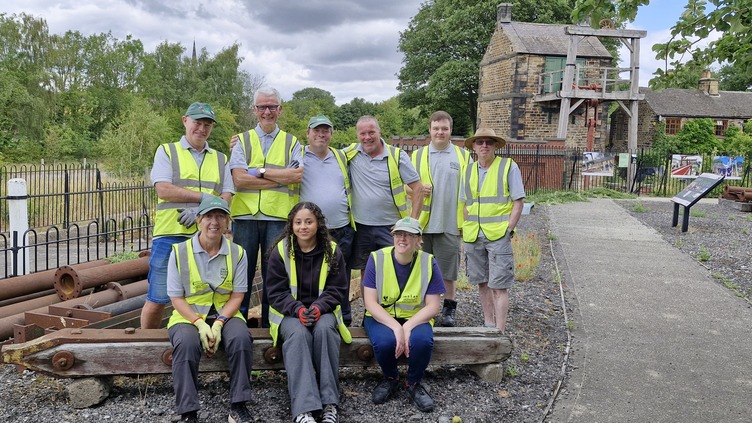 Litter picking volunteers in high vis vests outside the visitor centre