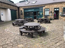 Circular brown picnic benches outside Brambles cafe 