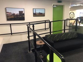 Wheelchair accessible ramp leading out of the visitor centre through a green door to the learning space