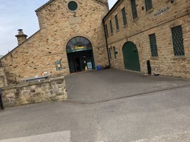 Entrance to Playmania children's soft play area, a stone building through a green door.