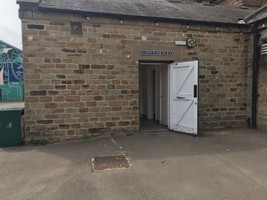 Public toilets entrance. A sign saying conveniences and a white door.